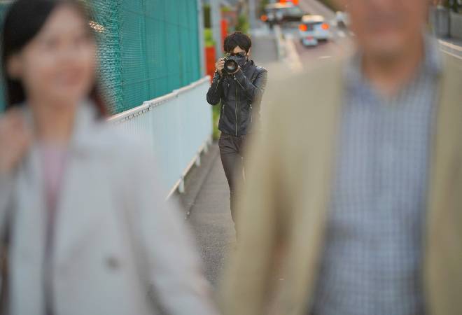 カメラを構える探偵。息子が探偵バイトで、危険な違法行為を行ってないか確認したい親御さんへ。