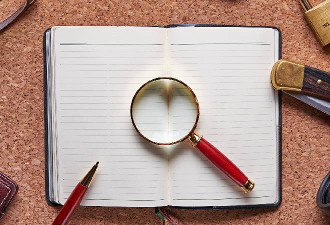 探偵が使うルーペとノートの写真。