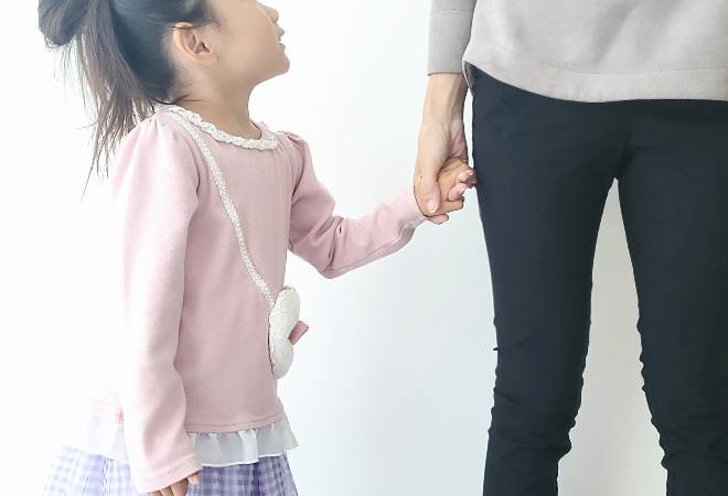 母親と手を繋ぐ小さい女の子の横顔の写真