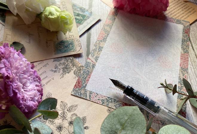 レトロなレターセットと花の写真、喧嘩別れした友への想いを綴ろうとしているイメージ。