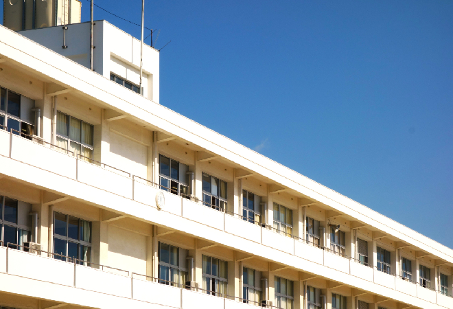 良く晴れた空の下、小学校の校舎の写真。